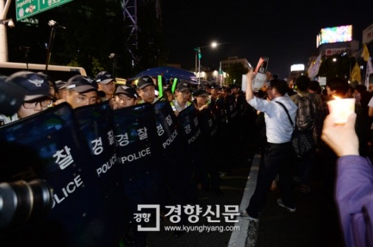 Protesters mourning the Sewol ferry victims and demanding that the government take responsibility being stopped by the police force. Source: http://news.naver.com/main/read.nhn?mode=LSD&mid=sec&sid1=102&oid=032&aid=0002478464